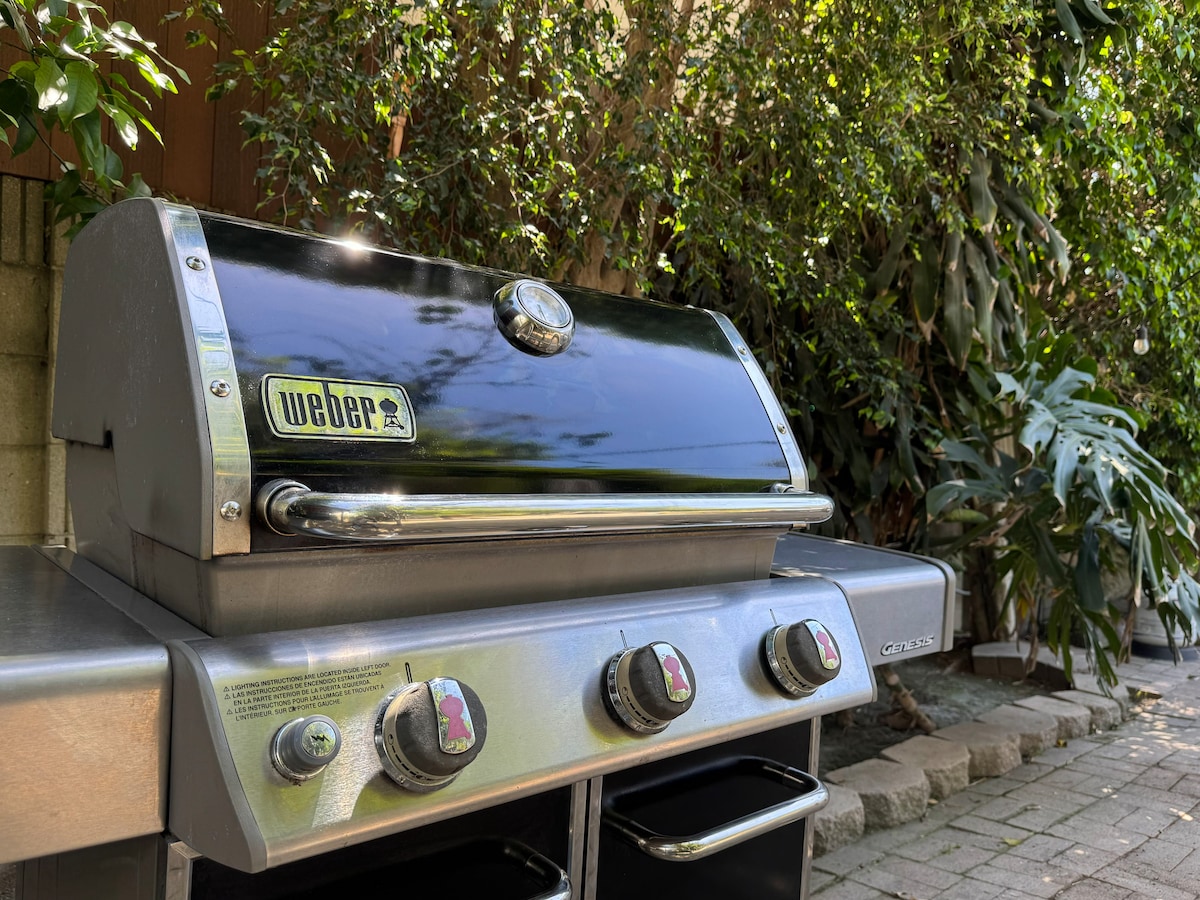 The Weber grill tucked beside the greenery
